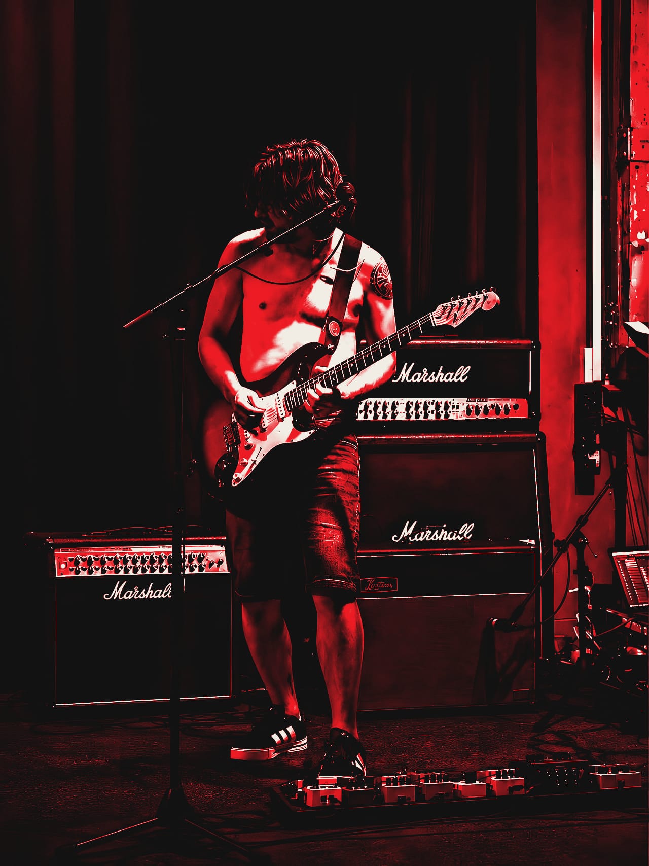 Mark, guitarist of De Peppers, plays a sunburst Stratocaster in front of a wall of Marshall amps